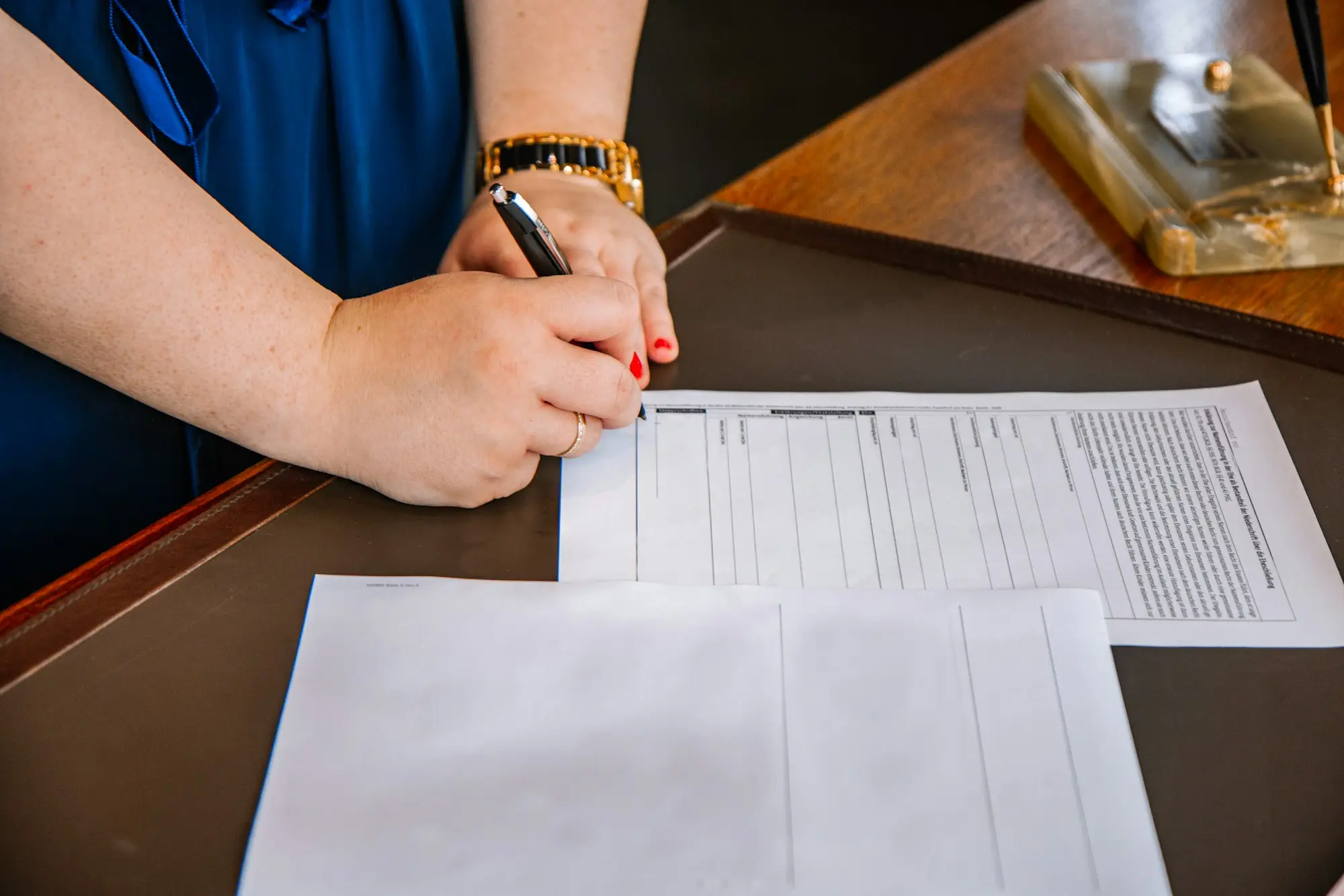 Shop owner signing a commercial lease document with a pen