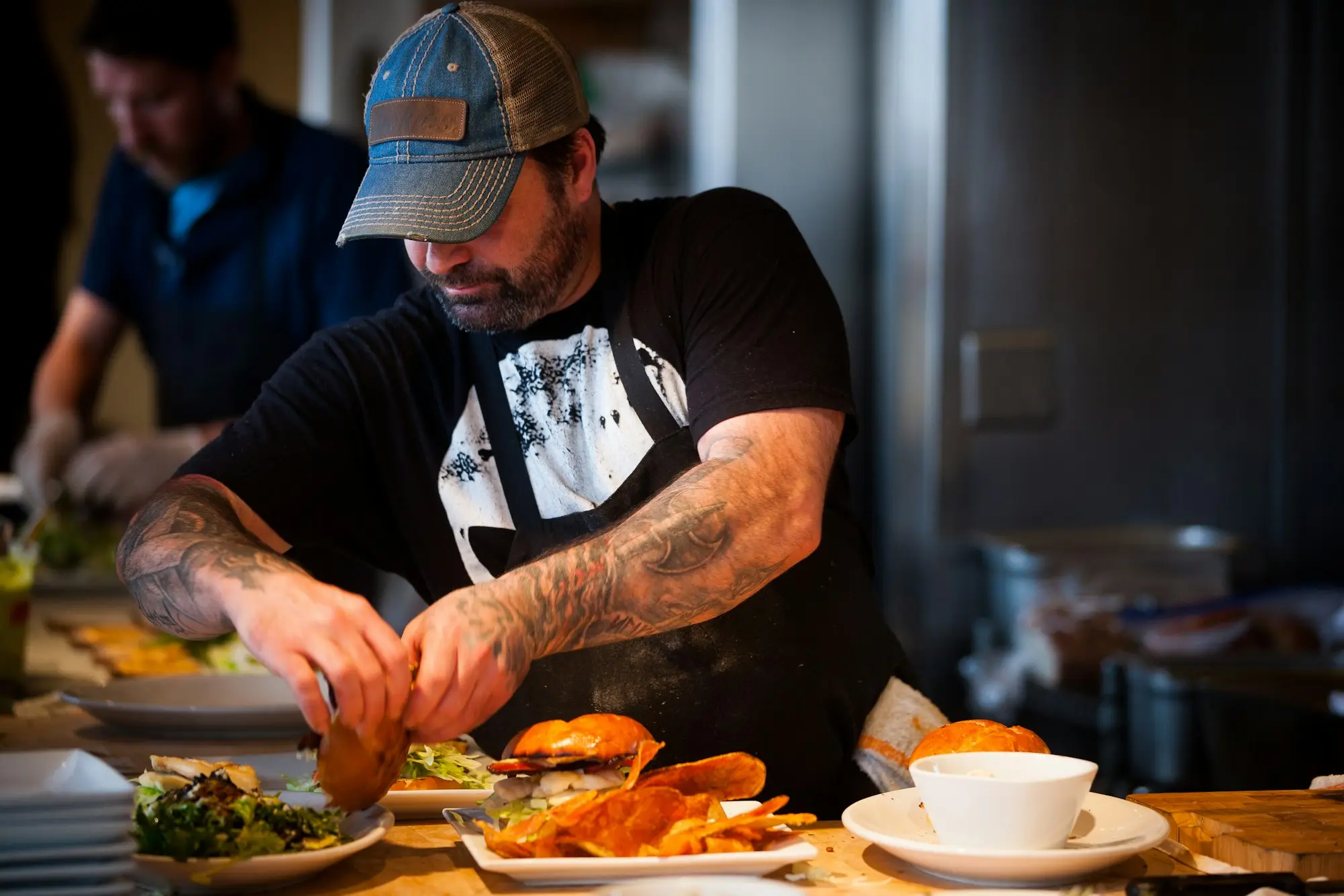 Chef plating food in a busy kitchen